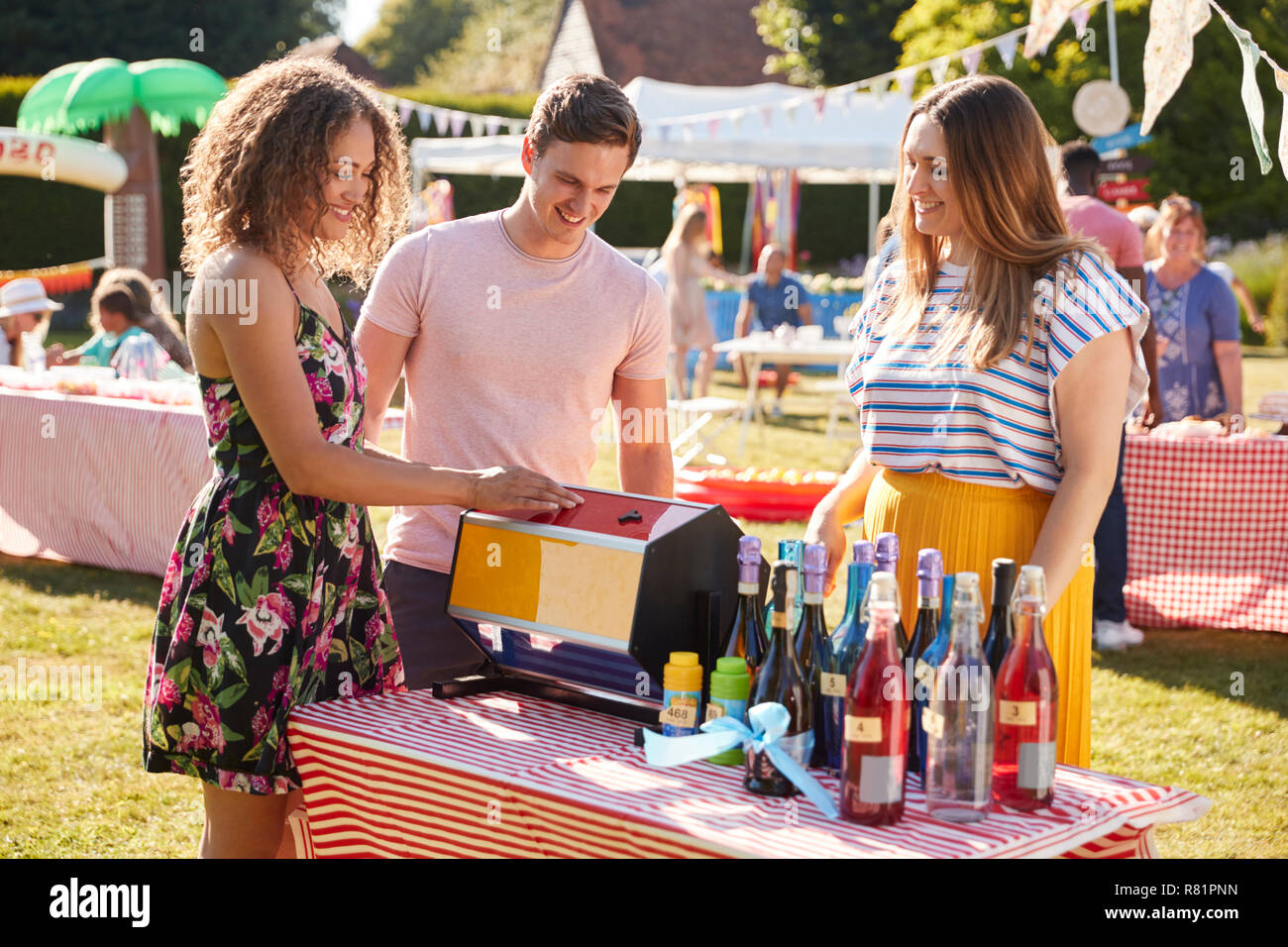 Couple At Tombola Stall At Busy Summer Garden Fete Stock Photo