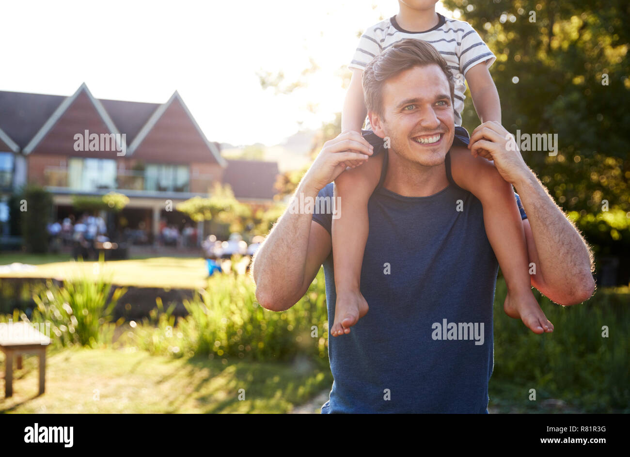 Father Giving Son Ride On Shoulders In Garden Of Pub Stock Photo