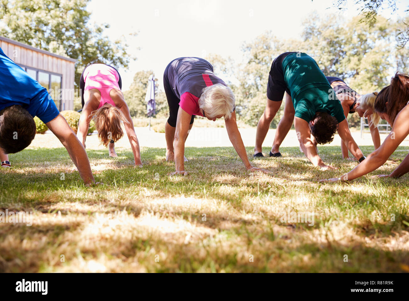 Female Instructor Leading Outdoor Yoga Class Stock Photo