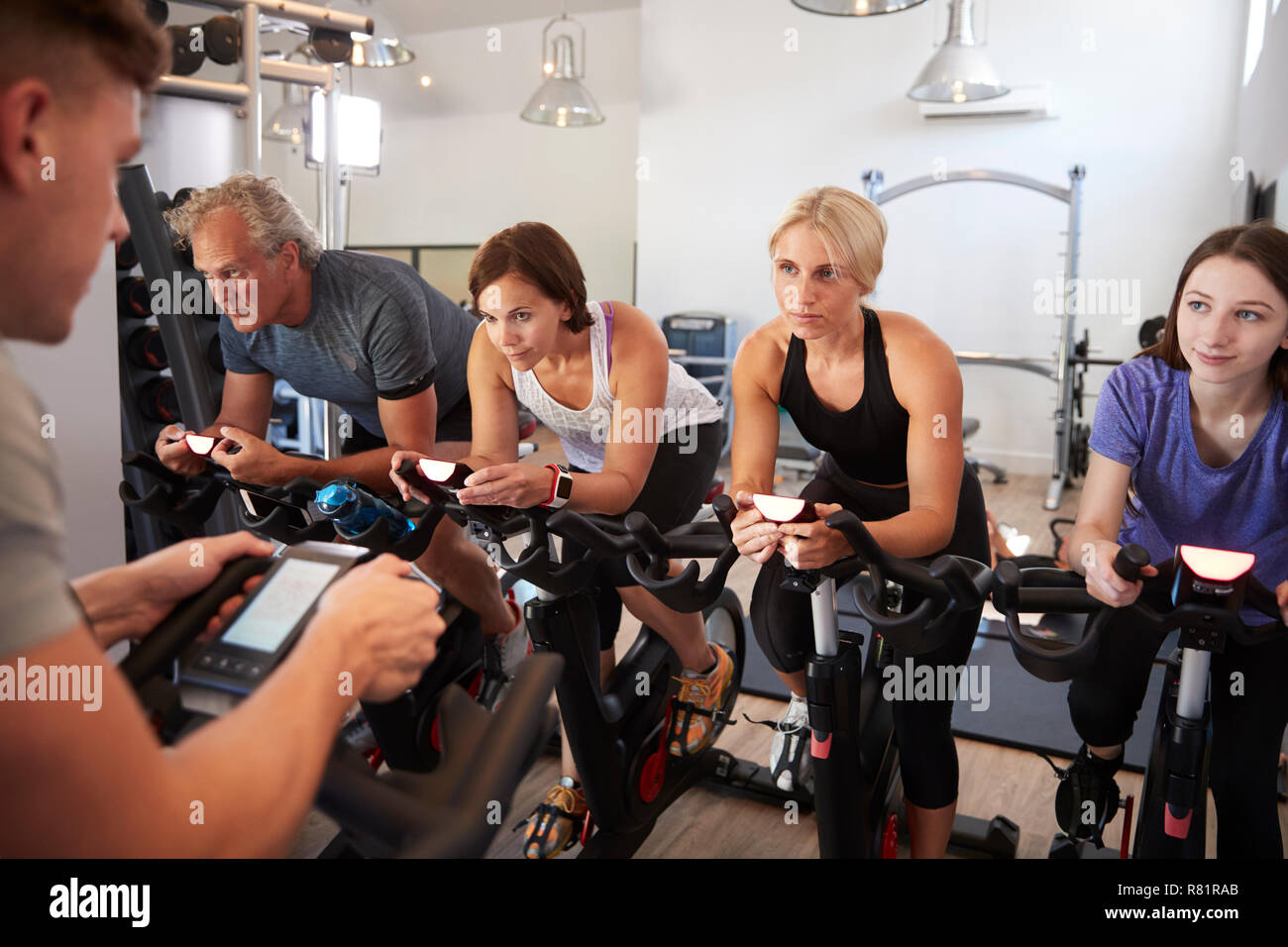 Male Trainer Taking Spin Class In Gym Stock Photo