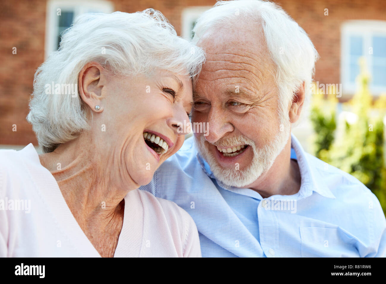 Retired Couple Sitting On Bench And Talking In Assisted Living Facility Stock Photo