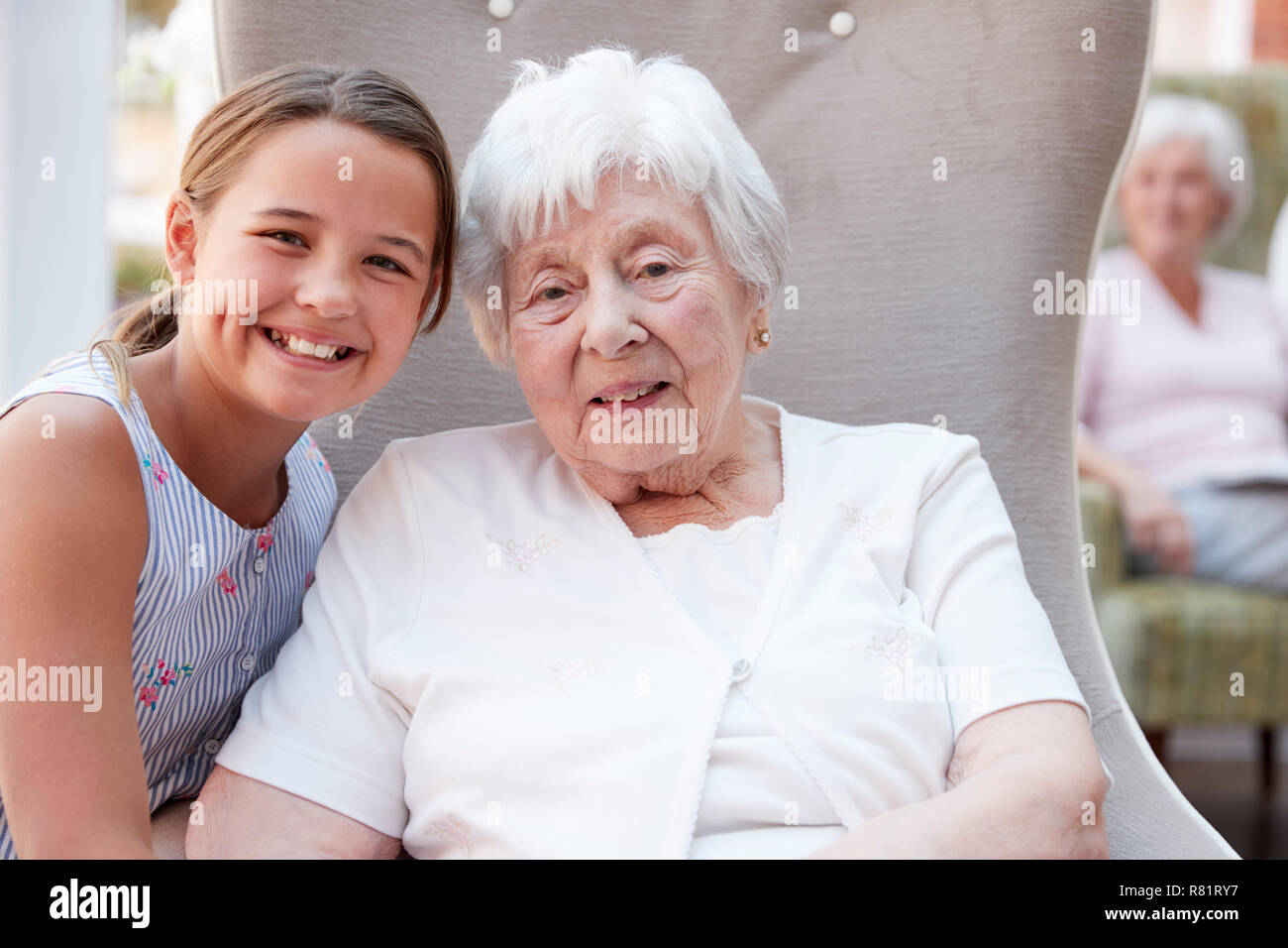 Portrait Of Granddaughter Visiting Grandmother In Retirement Home Stock Photo