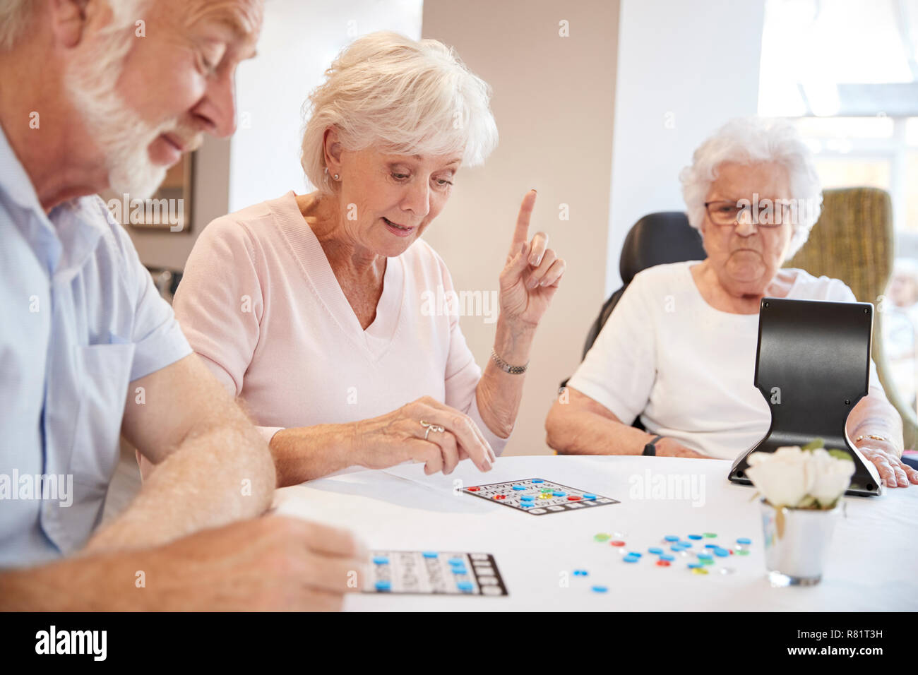 Group Of Seniors Playing Game Of Bingo In Retirement Home Stock Photo