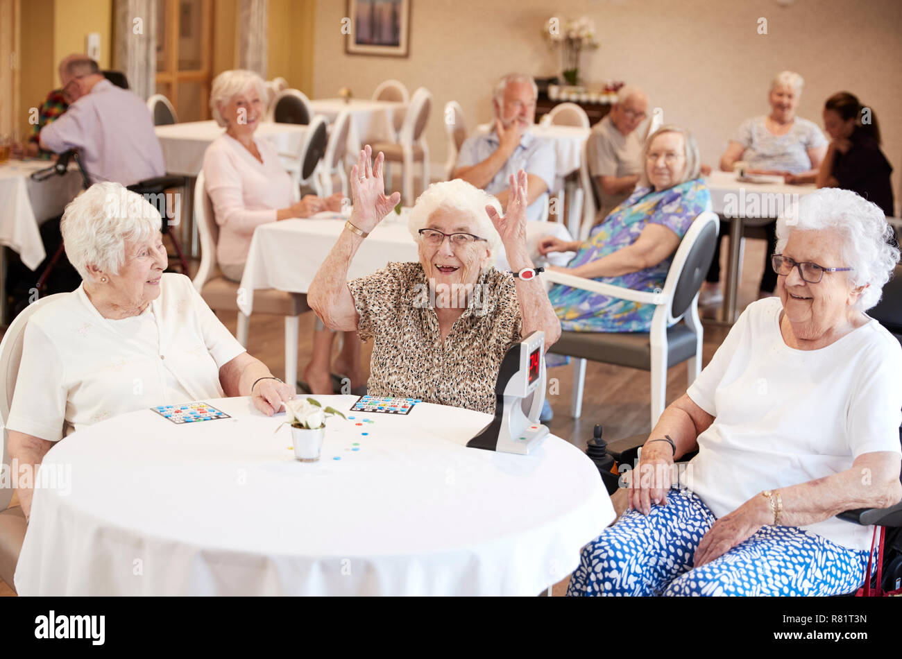 Senior Woman Winning Game Of Bingo In Retirement Home Stock Photo