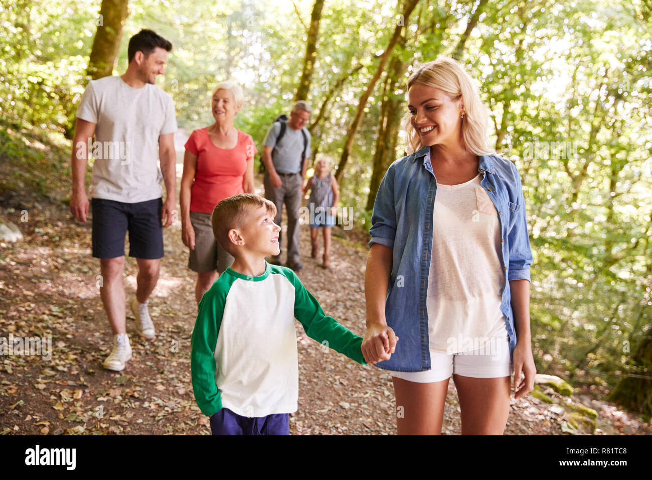 Multi Generation Family Enjoying Walk Along Woodland Path Together ...