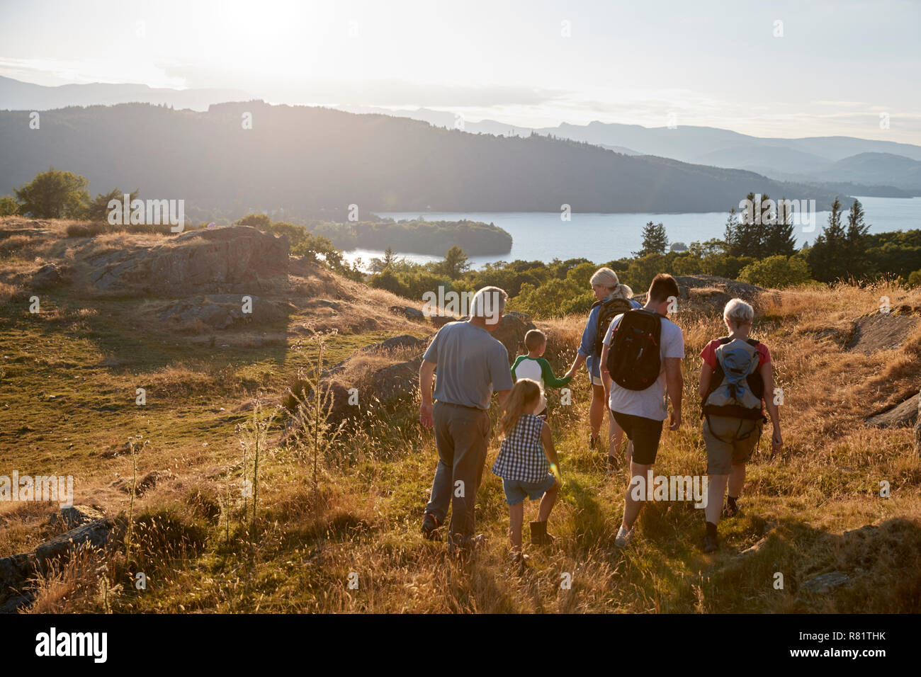 Rear View Of Multi Generation Family Walking On Top Of Hill On Hike Through Countryside In Lake District UK Stock Photo