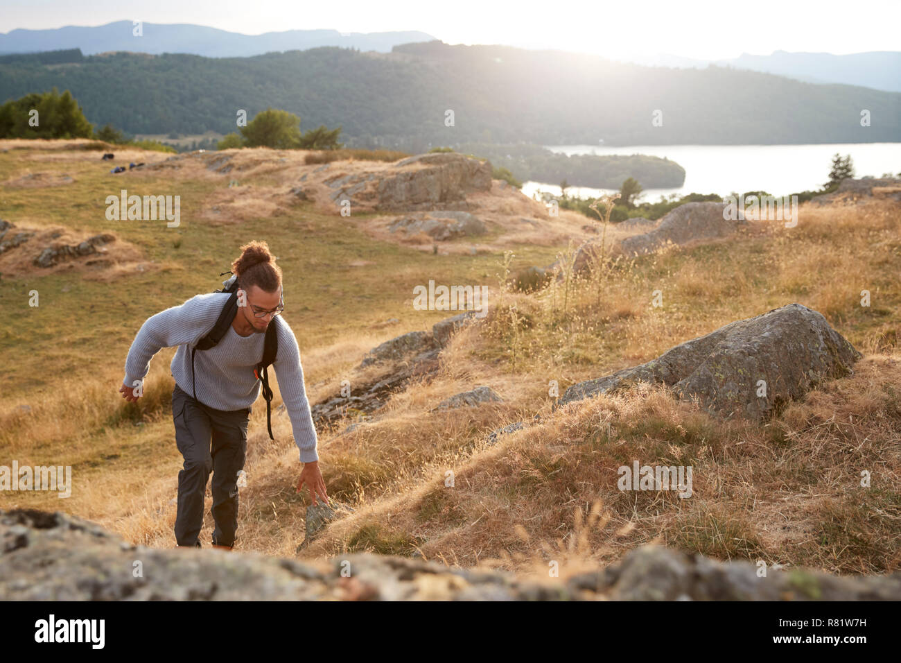 A young mixed race man hiking alone in the mountains Stock Photo