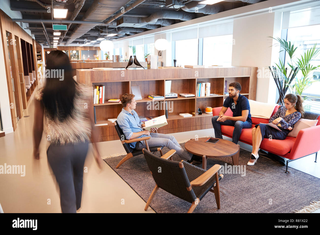 Casually Dressed Businessmen And Businesswomen Having Informal Meeting In Modern Office Stock Photo