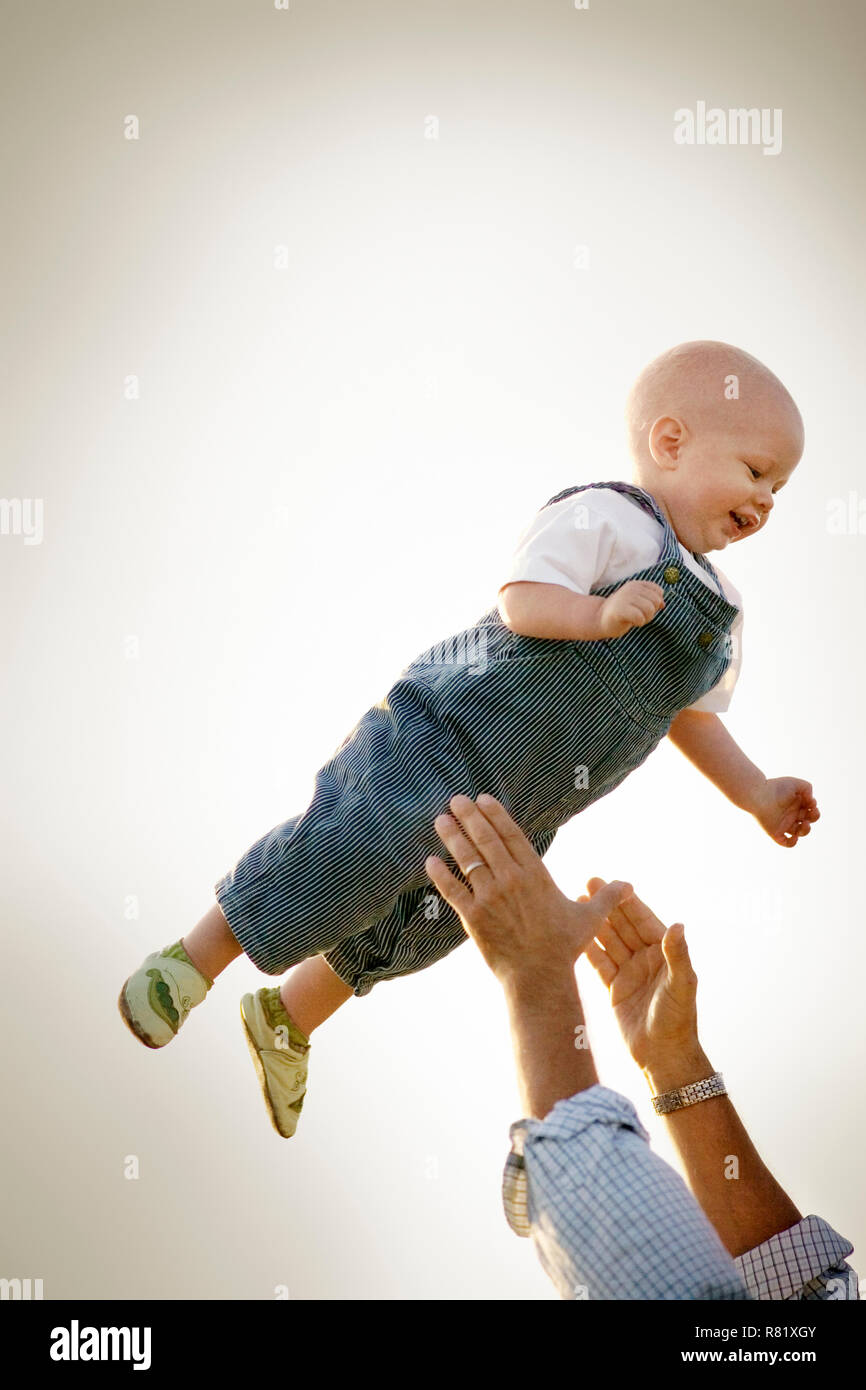 Young toddler being tossed in the air by his father. Stock Photo