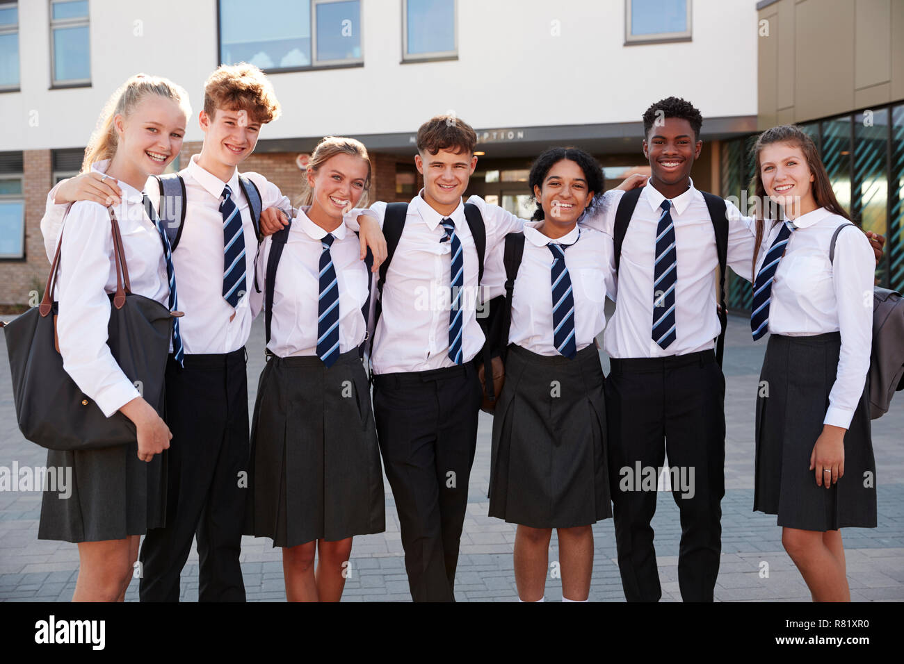 Portrait Of Smiling Male And Female High School Students Wearing Uniform Outside College Building Stock Photo