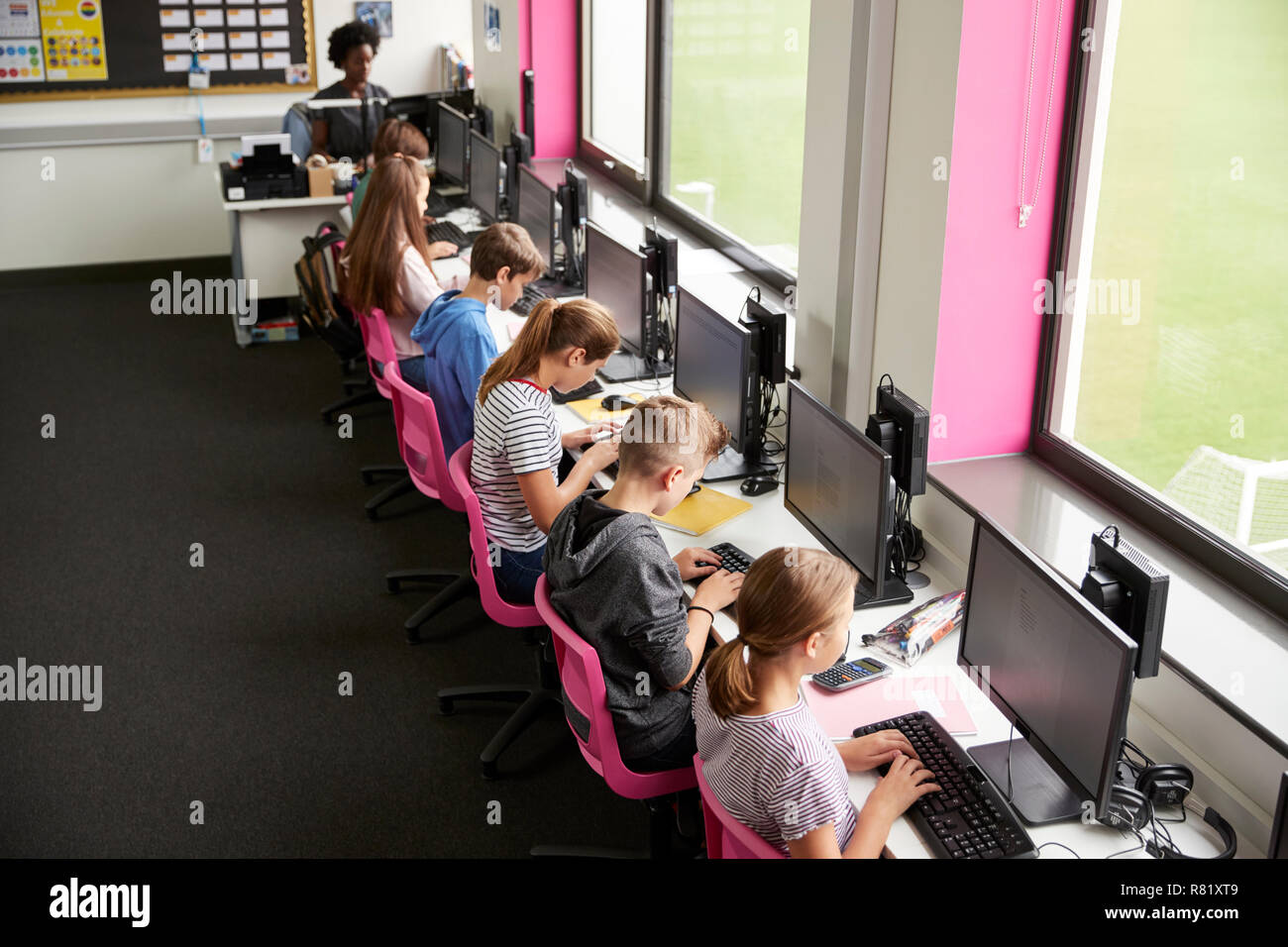 Line Of High School Students Working at Screens In Computer Class With  Female Teacher In Background Shot From High Angle Stock Photo - Alamy