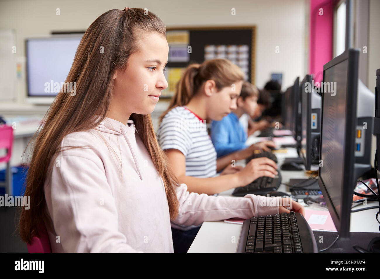 Line Of High School Students Working at Screens In Computer Class Stock Photo