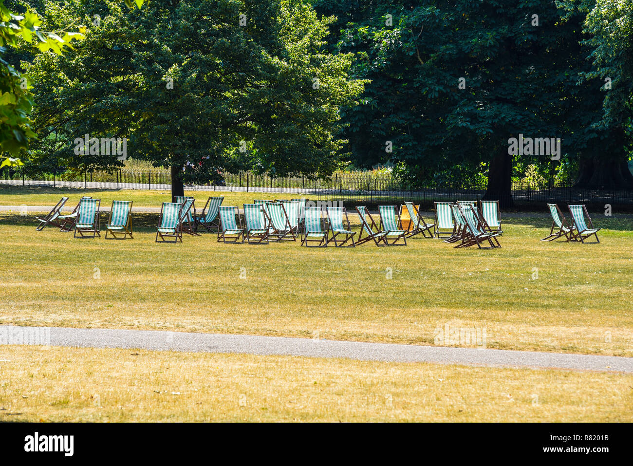 Empty deckchairs in St James's Park, London, UK. Sunny day in summer with brown grass. No customers for paid seating. Space for copy Stock Photo
