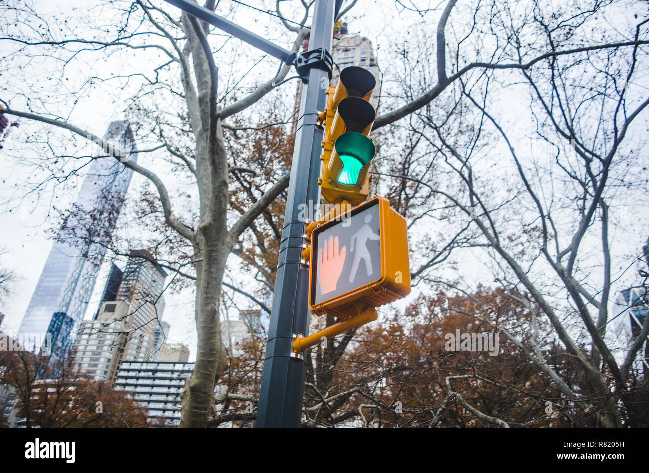 Green traffic light and red hand pedestrian stop sign at junction in New York City Stock Photo