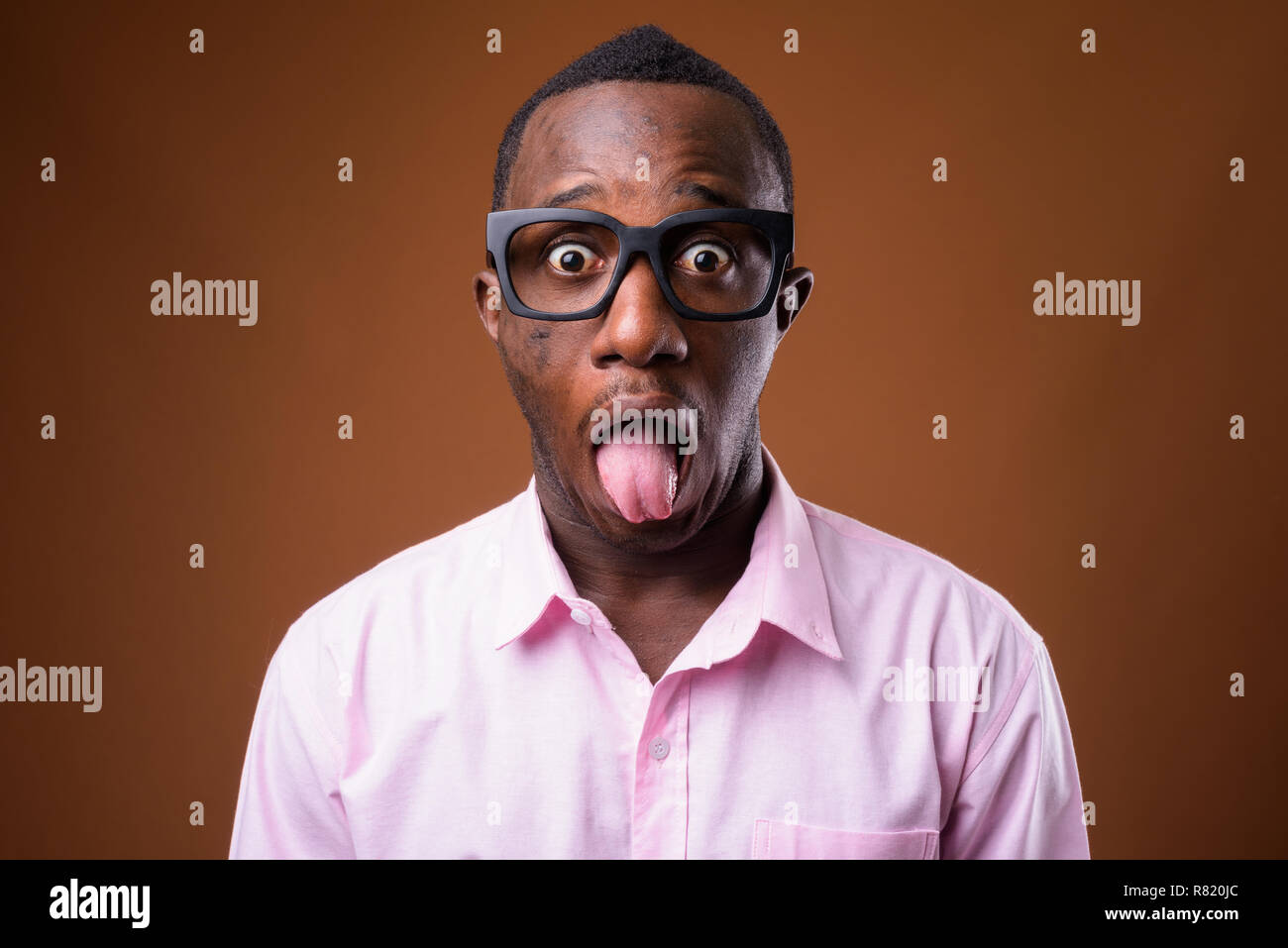Portrait of young African businessman against brown background Stock Photo
