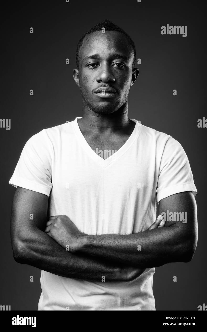Young African man against black background in black and white Stock Photo