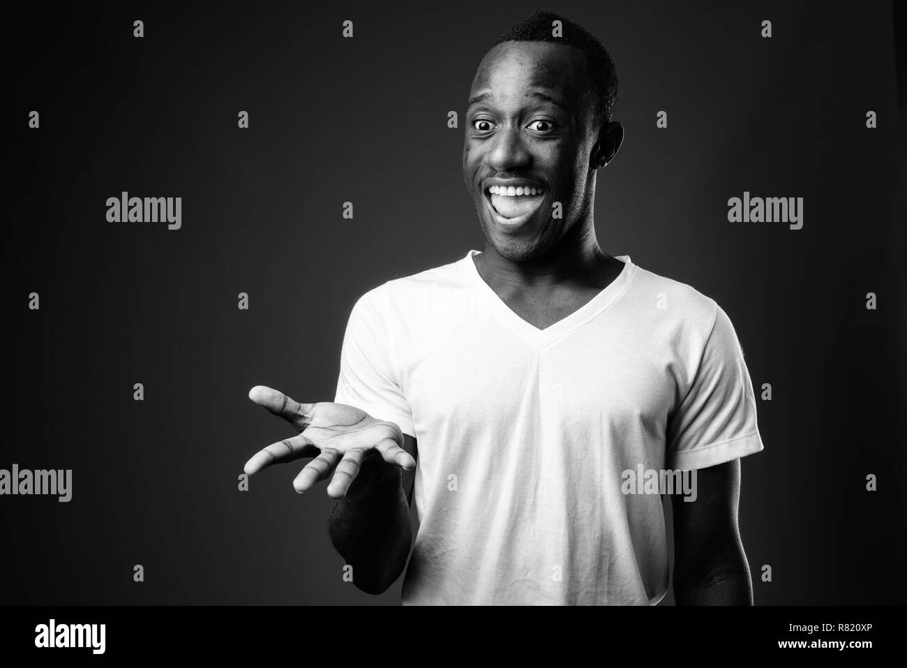 Young African man looking surprised with arm raised Stock Photo