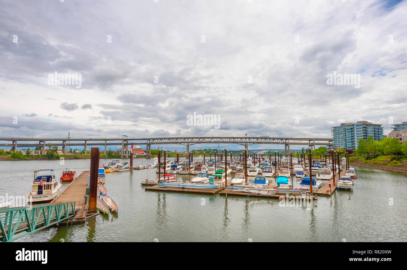 Portland, Oregon, USA - May 29, 2010:  View of boats docked on the Willamette River and the Marquim Bridge that crosses it  under cloudy skies. Stock Photo