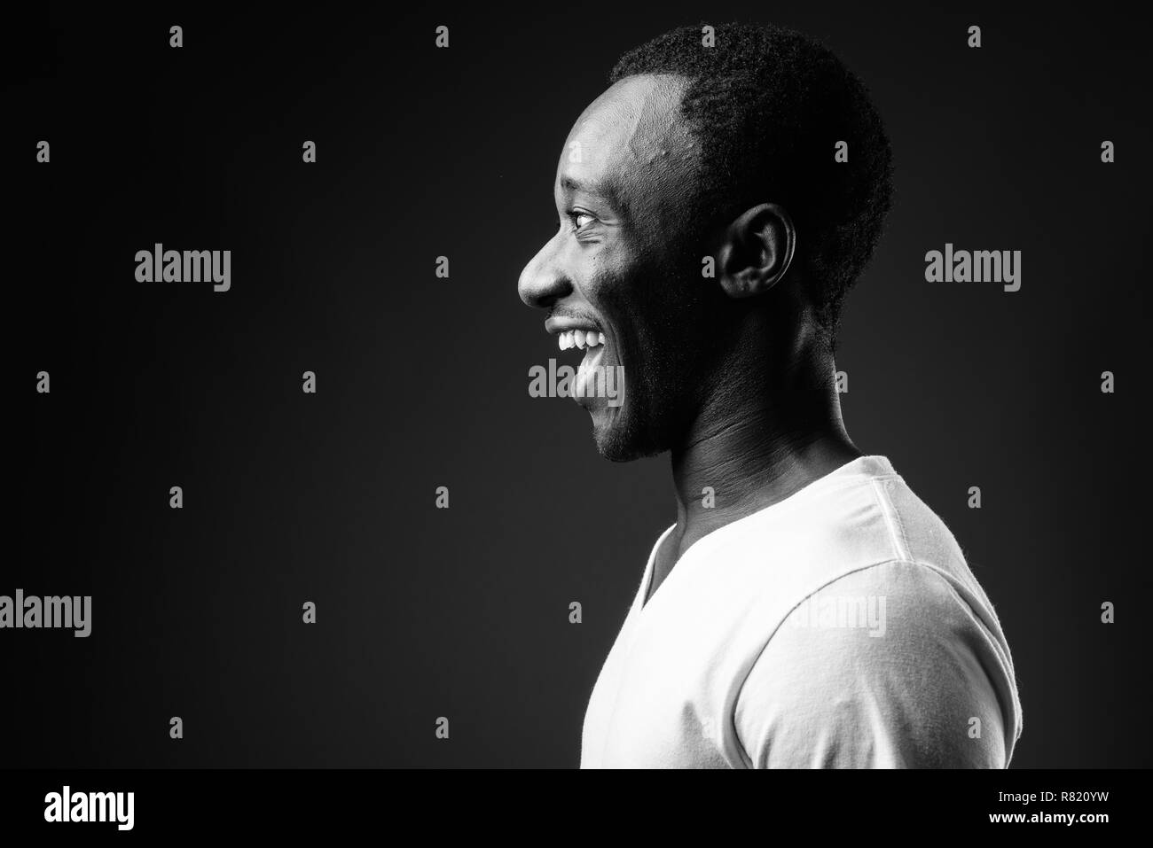 Profile view portrait of young African man smiling in black and white Stock Photo