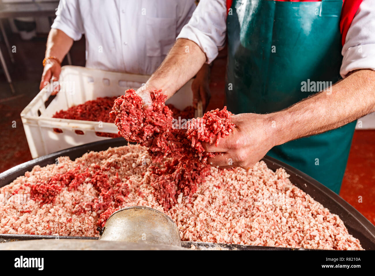 Butchers processing sausages at meat factory. Stock Photo