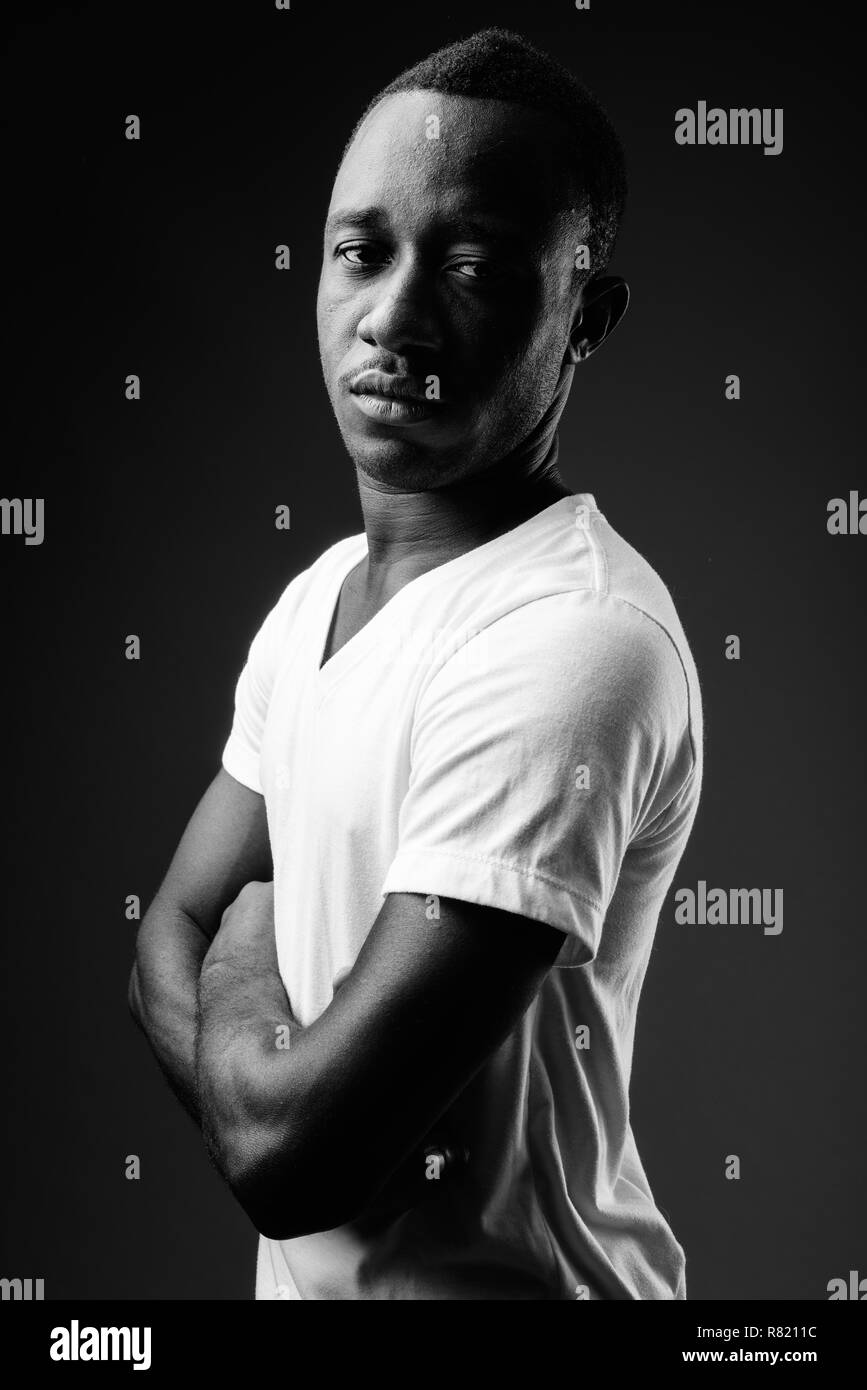 Young African man against black background in black and white Stock Photo