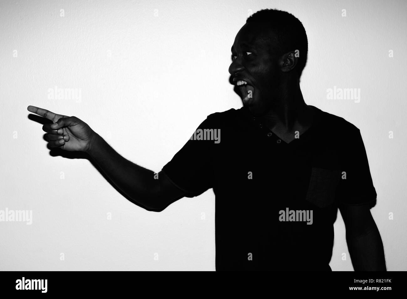 Spooky horror portrait of young African man pointing finger Stock Photo