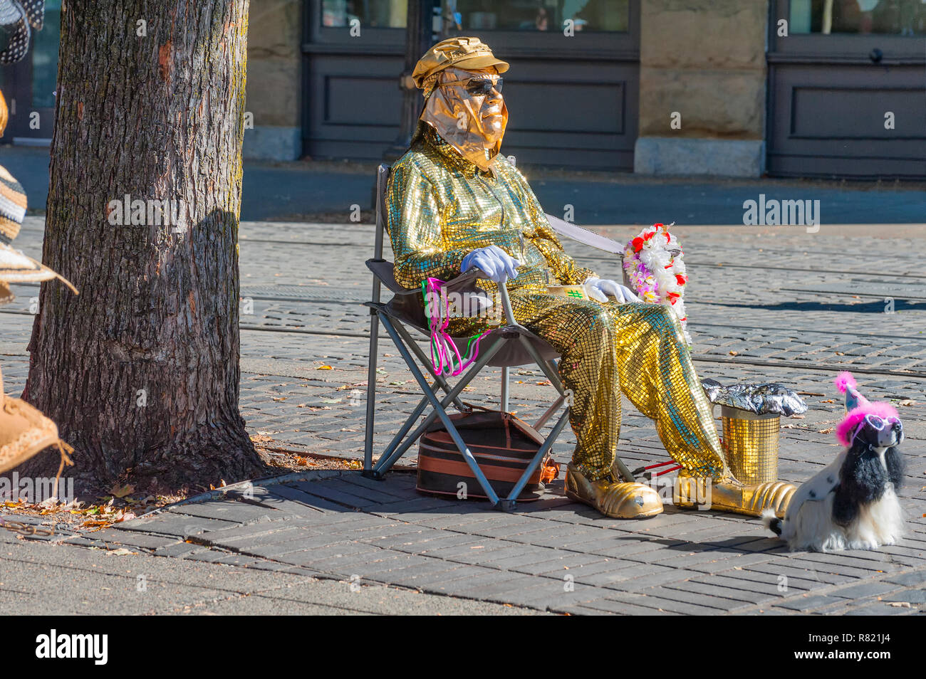 Portland, Oregon, USA - September 20, 2014: A street entertainer dressed as a foil man sits in a camp chair along the Max rails in Ankeny Square with  Stock Photo