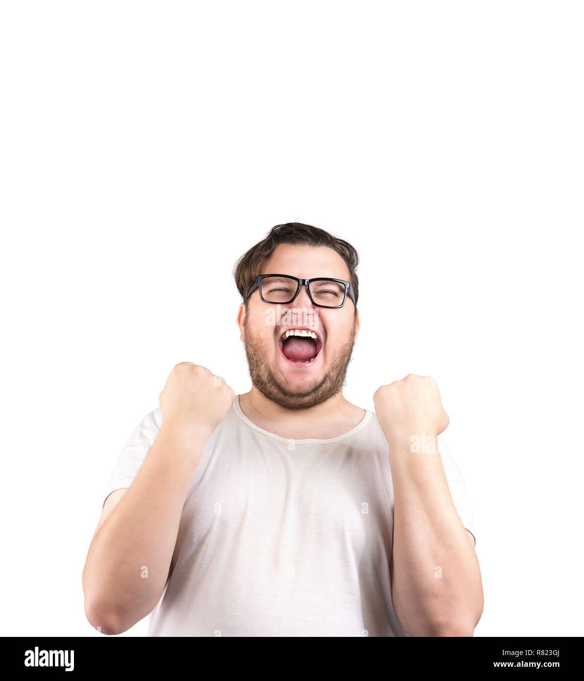 Obese man in glasses holding fists in excitement of victory while screaming isolated on white background Stock Photo