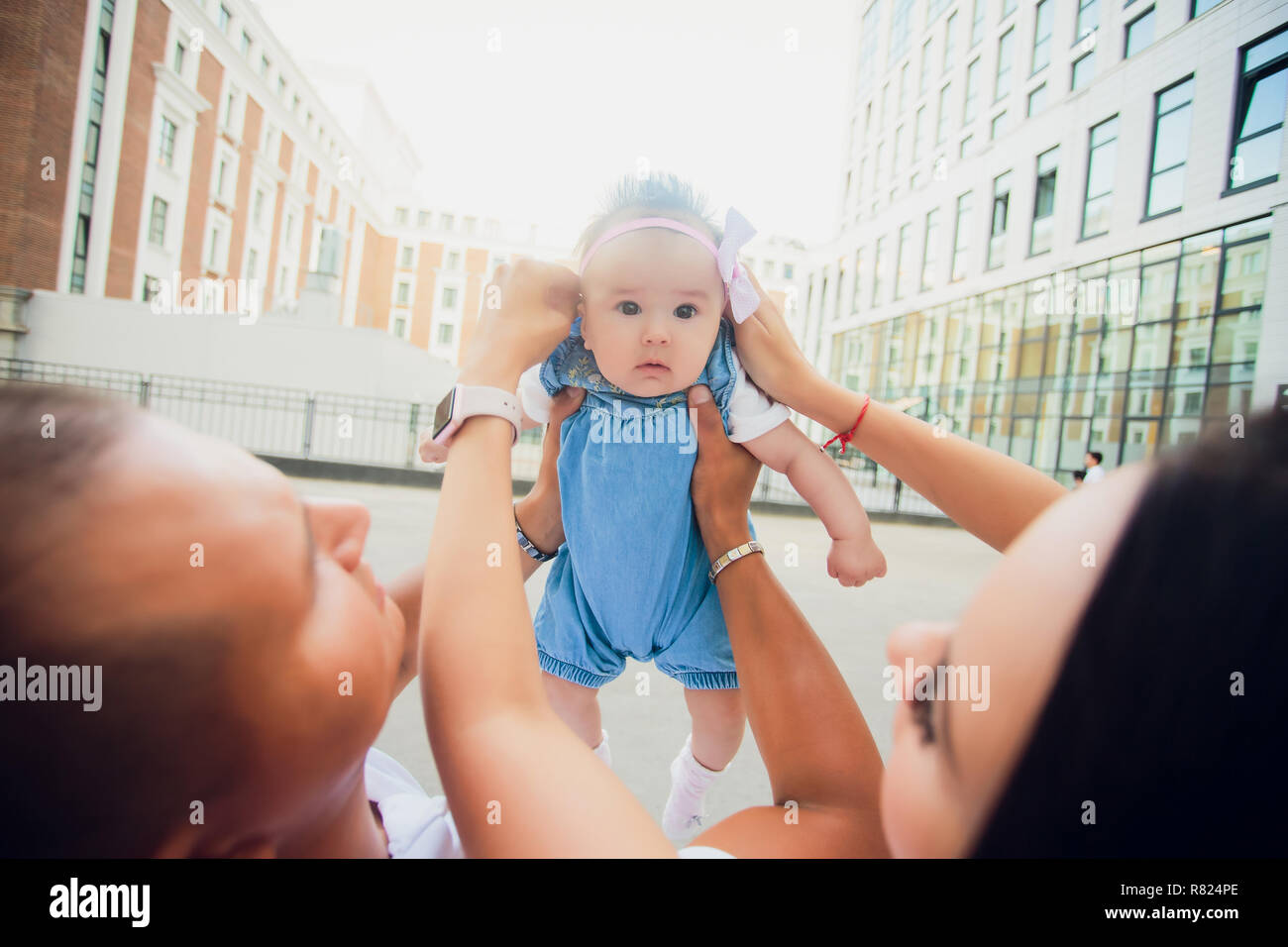 father holds his daughter on background skyscrapers. glass buildings. child on sky background Stock Photo