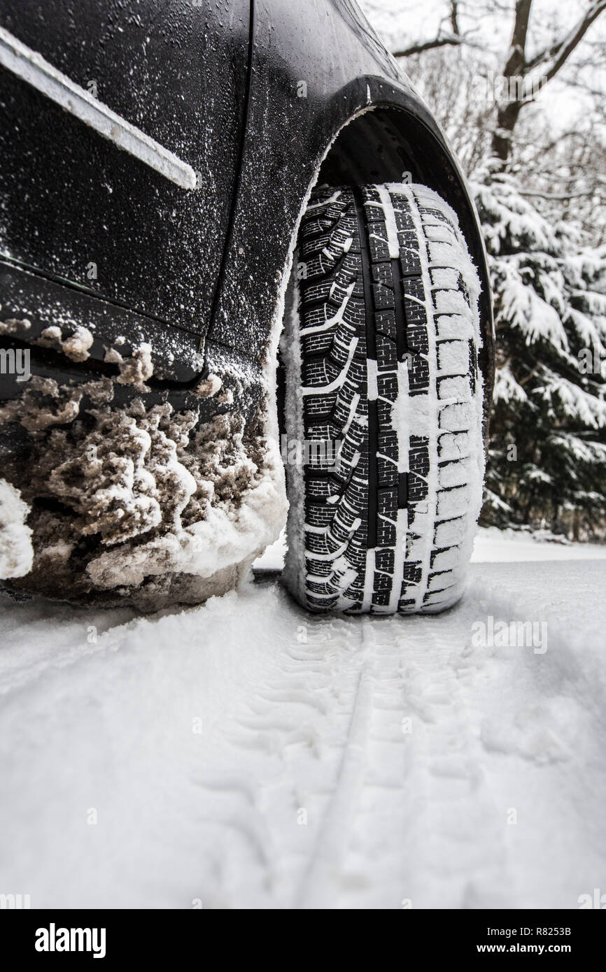 Car with winter tyres parked on a road covered with snow Stock Photo