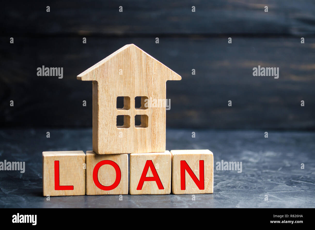 Model of the house and the inscription 'Loan'. Buying a home in debt. Family investment in real estate and risk management concept. Loan for a mortgag Stock Photo