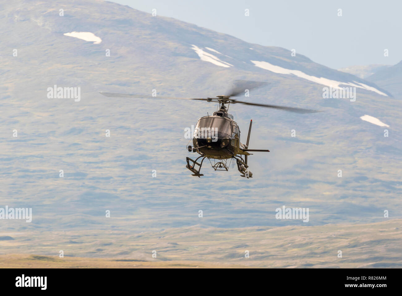 Helicopter flying in a mountain landscape in the wilderness Stock Photo