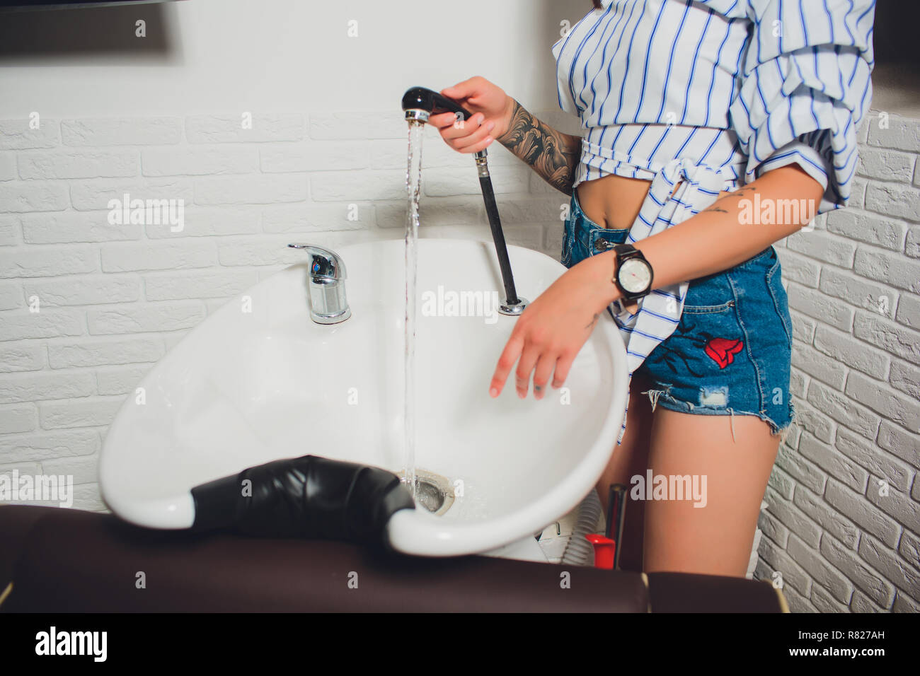 portrait of woman hairdresser shaving man's beard in Stock