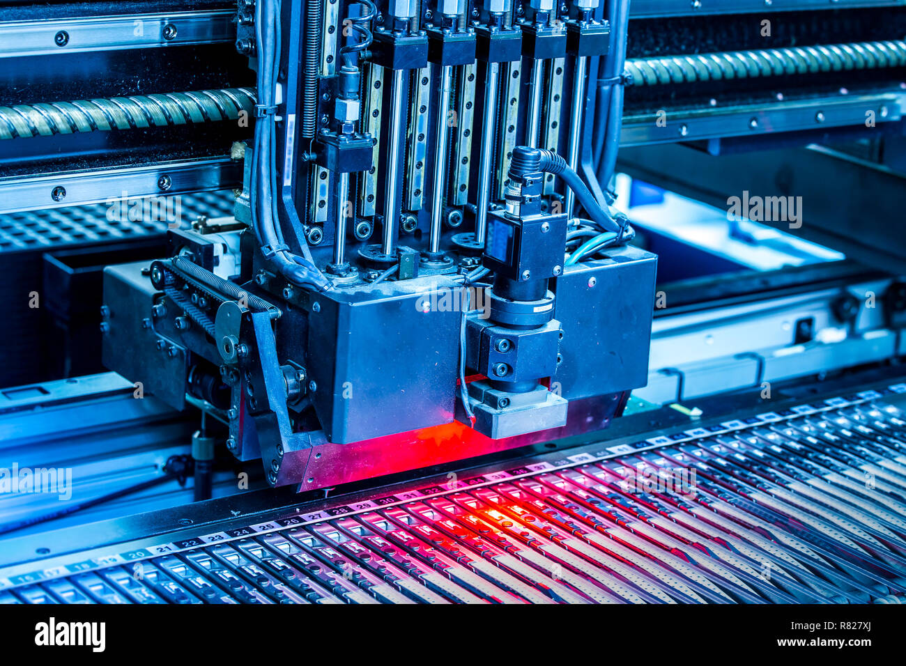 Close-up surface-mounting machine in progress. SMT (surface-mount technology) is a method for producing electronic circuits. Components are placed directly onto the surface of printed circuit boards. Stock Photo