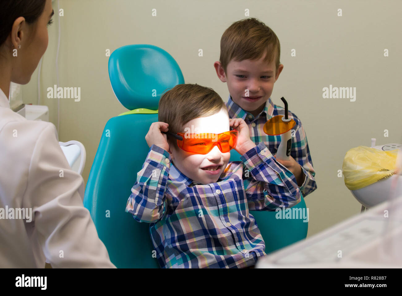 Reception at the dentistry. A little boy lays on the couch and holding