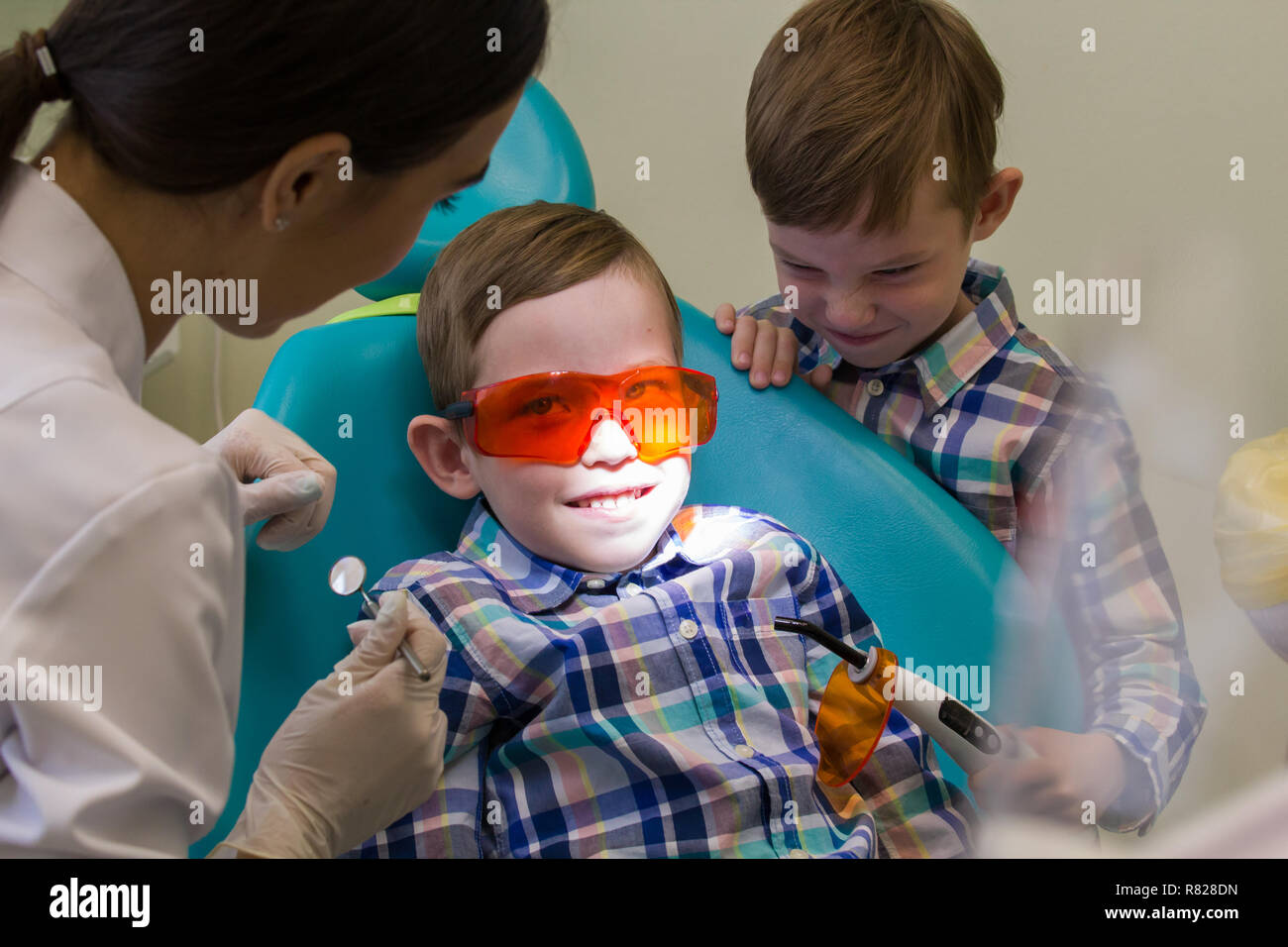 Reception at the dentistry. A smiling little boy lays on the couch