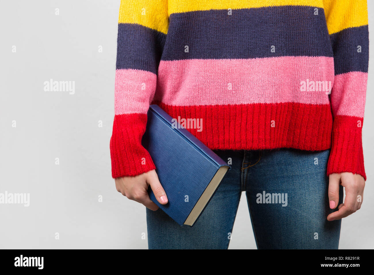Confident smart student girl holding book in one hand over white