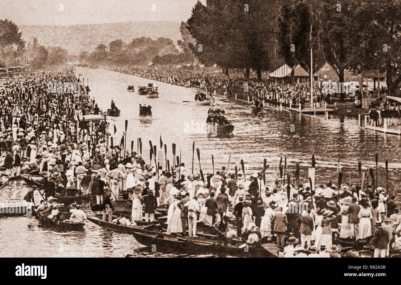 Oars raised in salute as the Royal Barge bearing  King George V and the Royal family makes its way down the regatta course on July 6th 1912 at Henley-on-Thames, a town on the River Thames in Oxfordshire, England.  It was the only occasion that the king attended Henley Royal Regatta, even though it became 'Royal' in 1851, when Prince Albert became patron of the regatta. Stock Photo