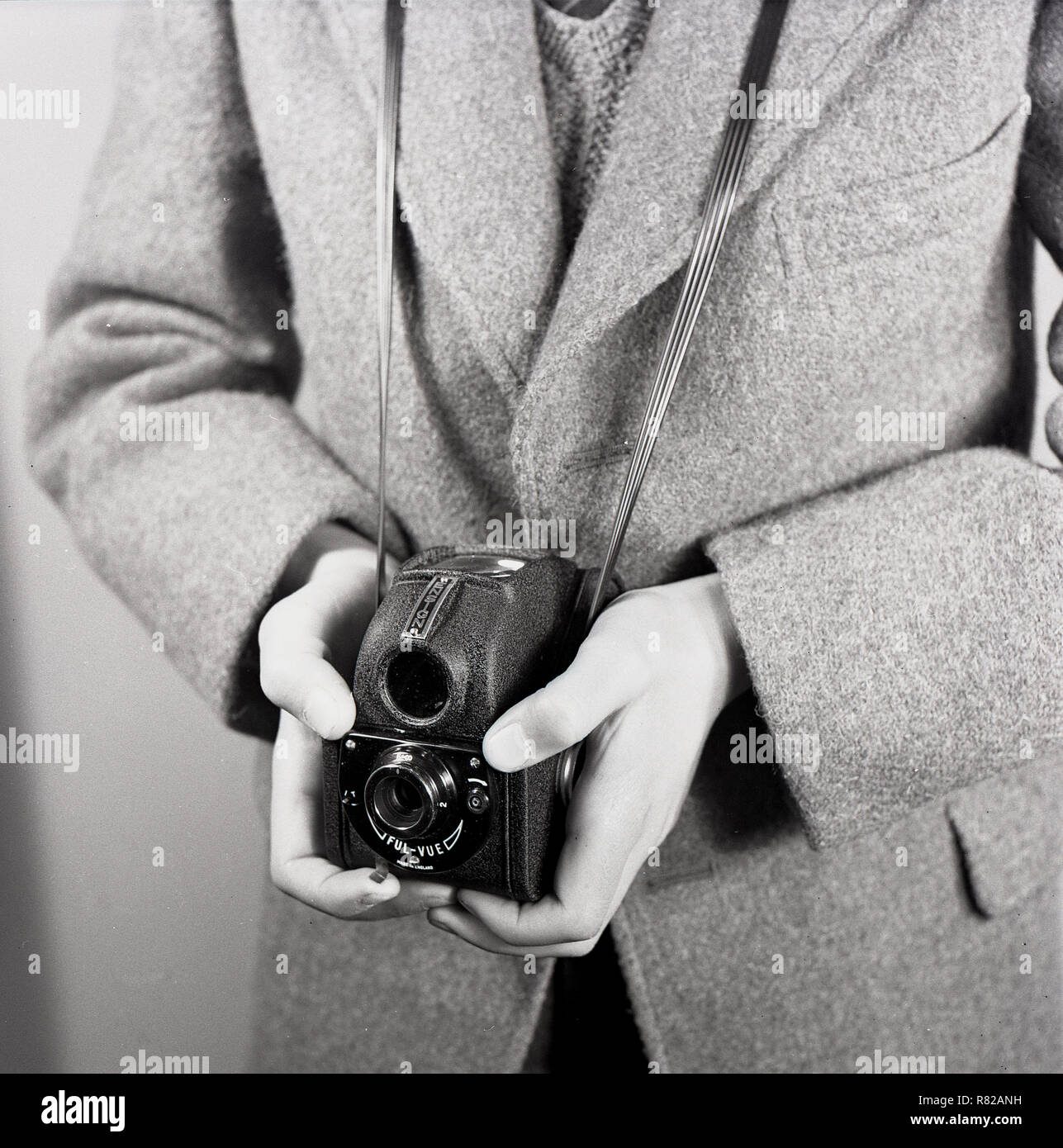 1950s, historical, film photography, a schoolboy in a woollen jacket using a British made Ensign Ful-Vue box camera, England, UK. The design was modern for its day and a move away from the traditional conventional box camera design. Stock Photo