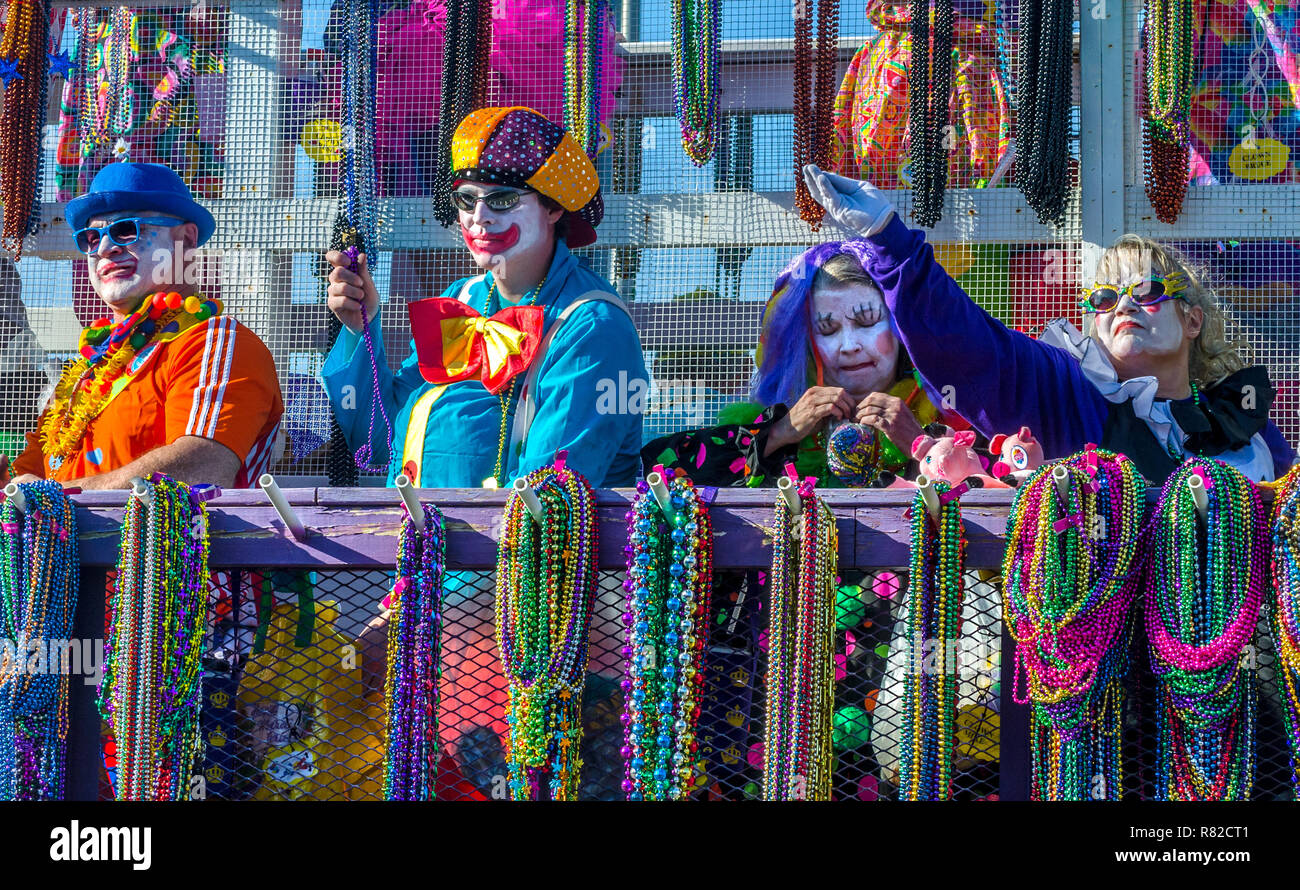 A member of the Clown Arounds throws Mardi Gras beads during the Joe