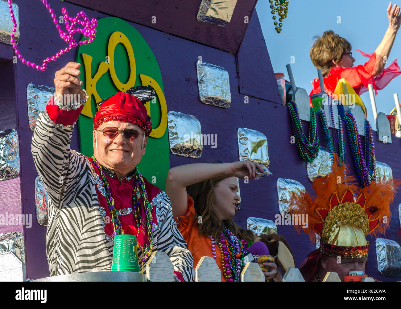 Members of the Knights of Daze throws beads as their float travels down