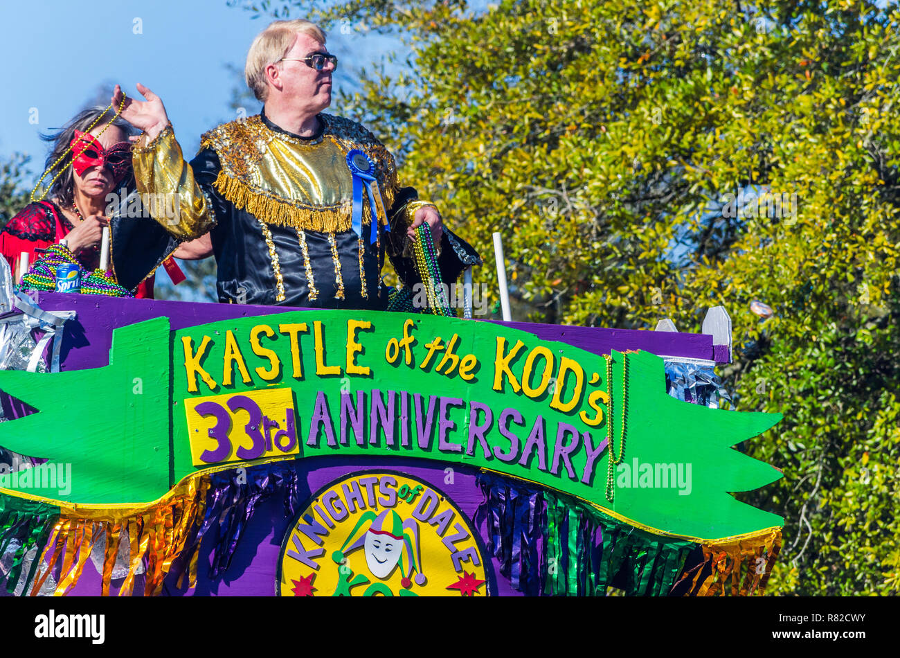 A member of the Knights of Daze throws beads as his float travels down