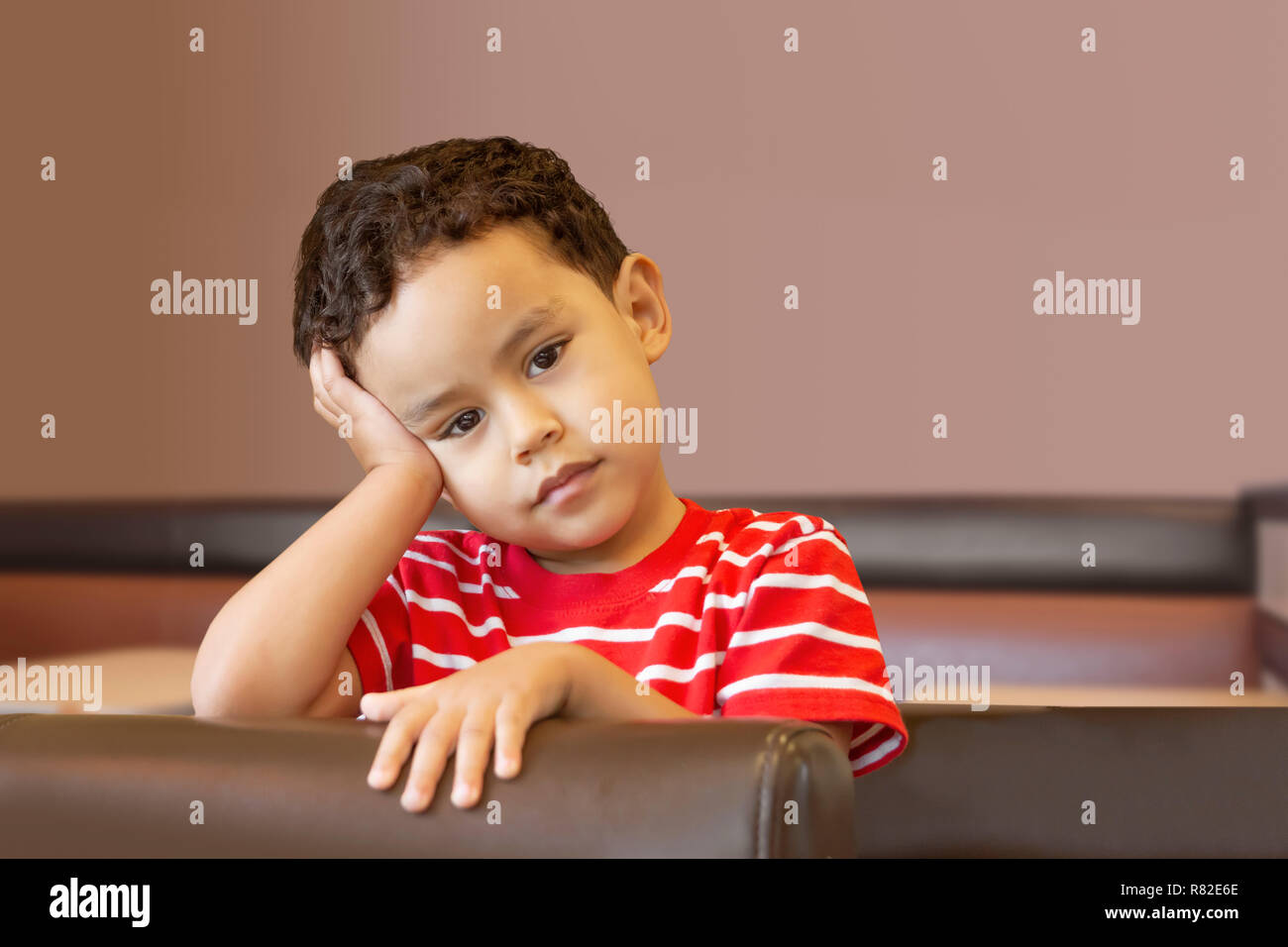 With the elbow on top of the booth, he supports his head with his hand calmly looking. Stock Photo