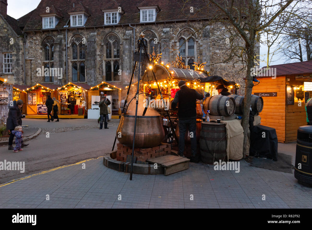 Winchester, Hampshire, England, December 12 2018. Christmas market stalls in the grounds of Winchester Cathedral with one selling gluhwein Stock Photo