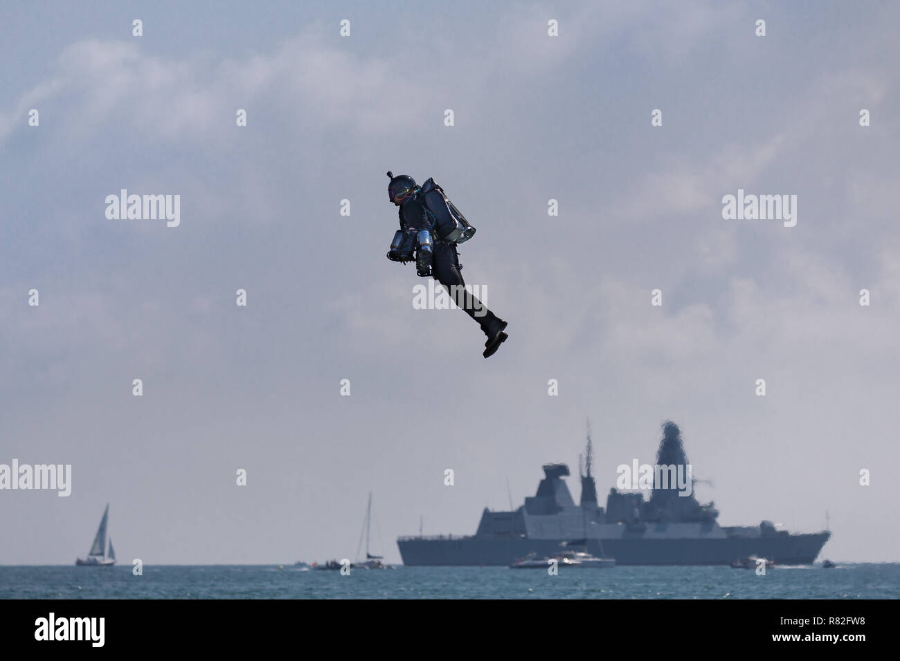 Gravity jet man hovers in front of naval vessel Stock Photo