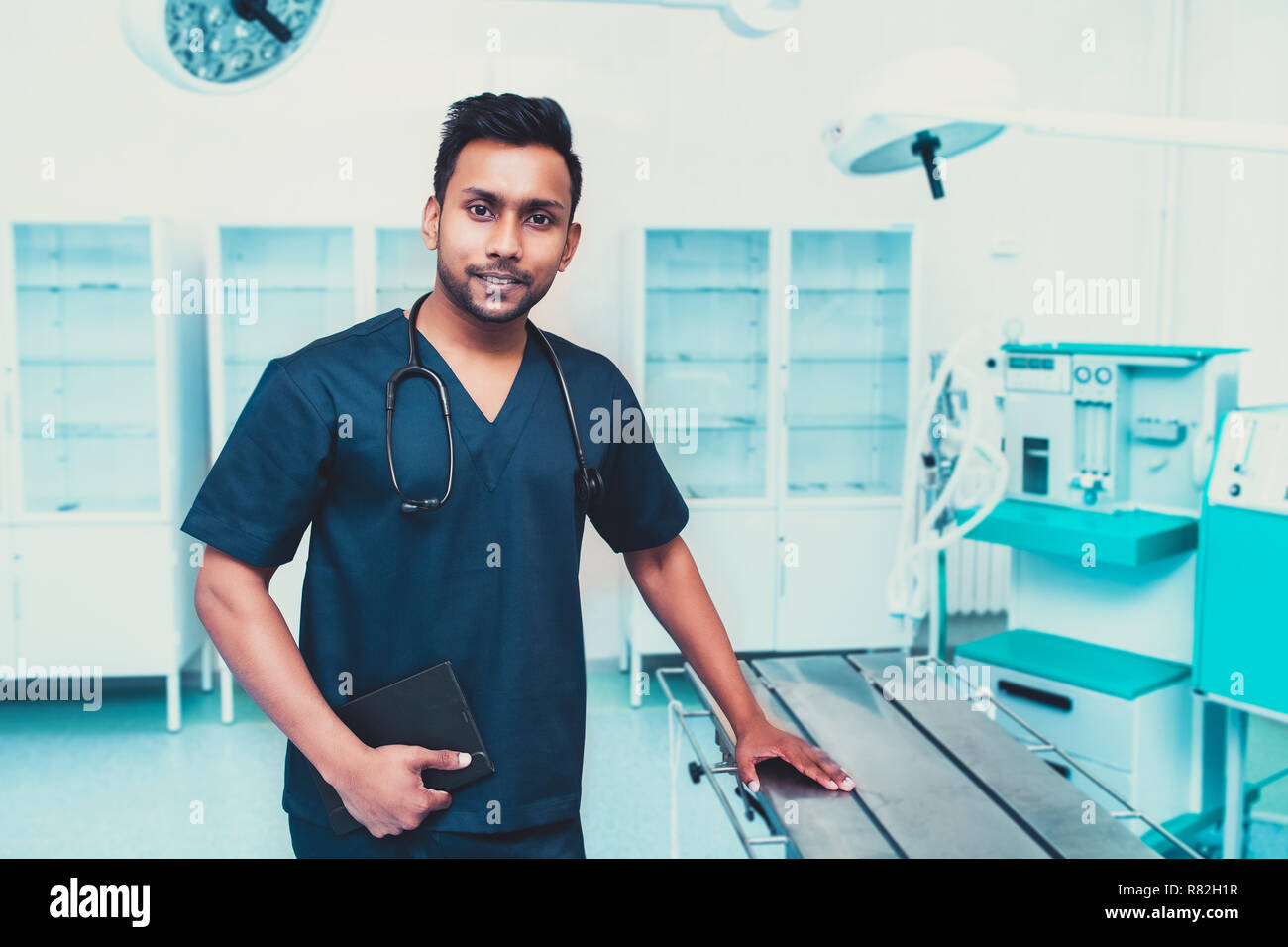 surgeon man relaxed smile confident in surgical room hospital, medical
