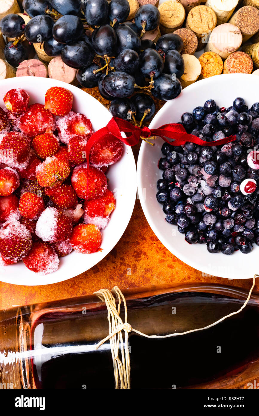 strawberry, blueberry, grape on wine corks, red wine with ripe
