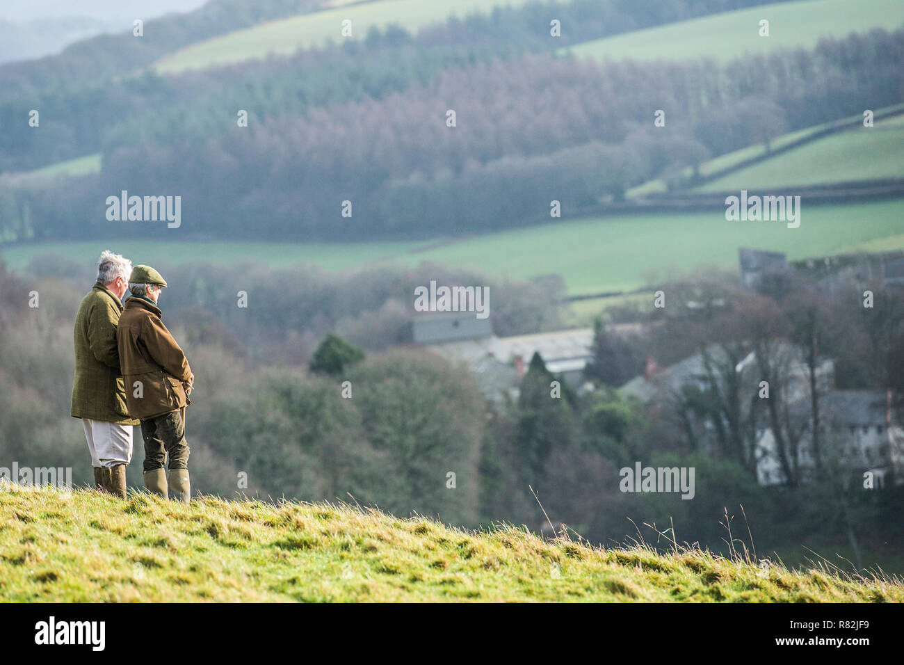 walkers admiring view from hilltop in Devon Stock Photo