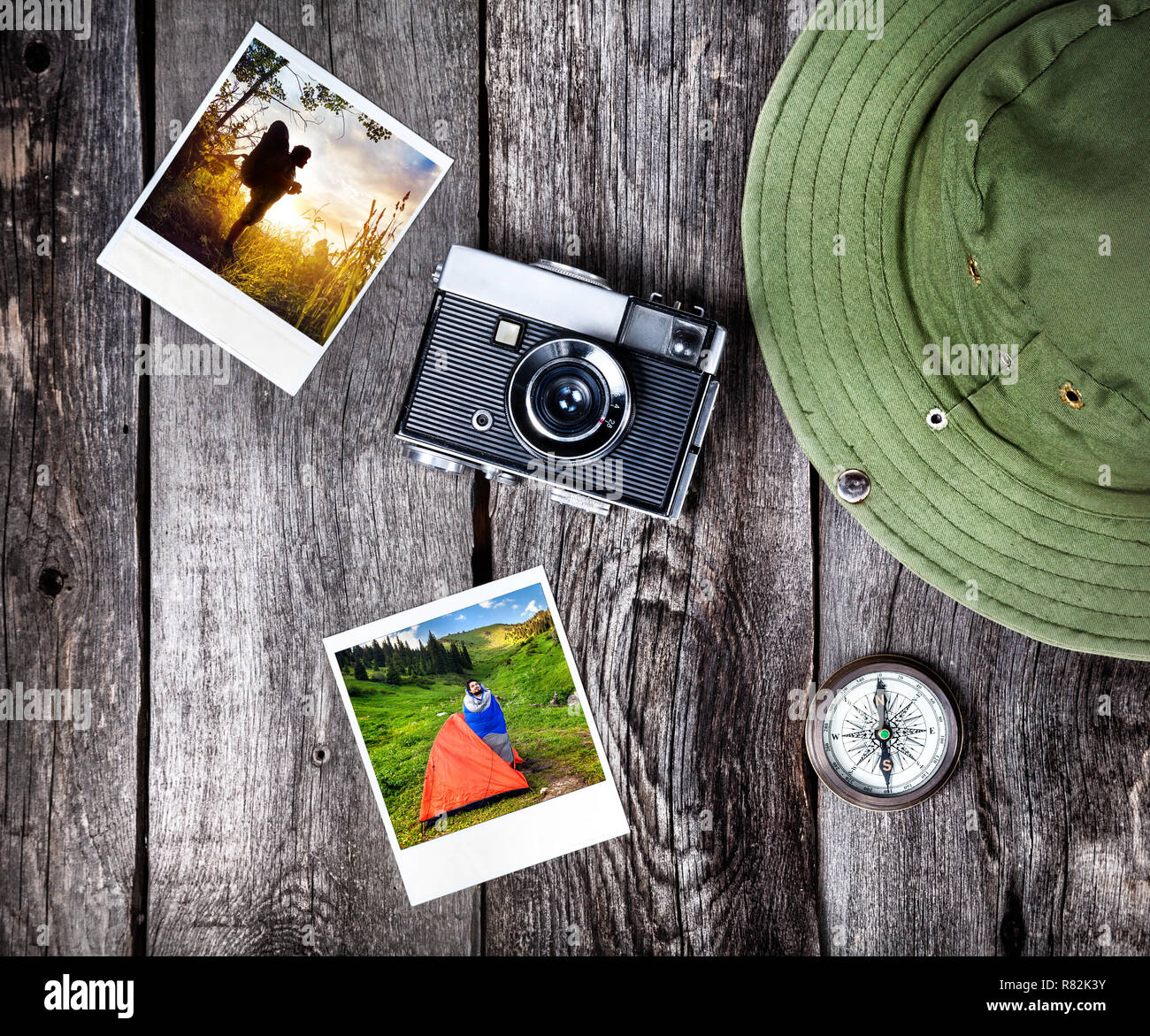 Old film camera, photos with tourist in nature, hat and compass on the wooden background Stock Photo