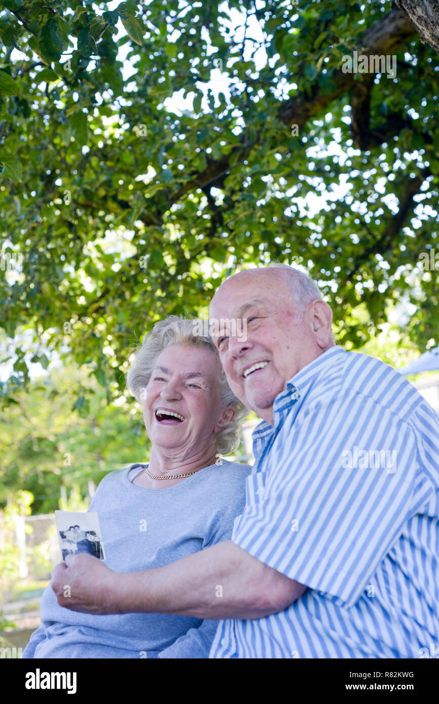 Elderly couple showing picture of their wedding Stock Photo